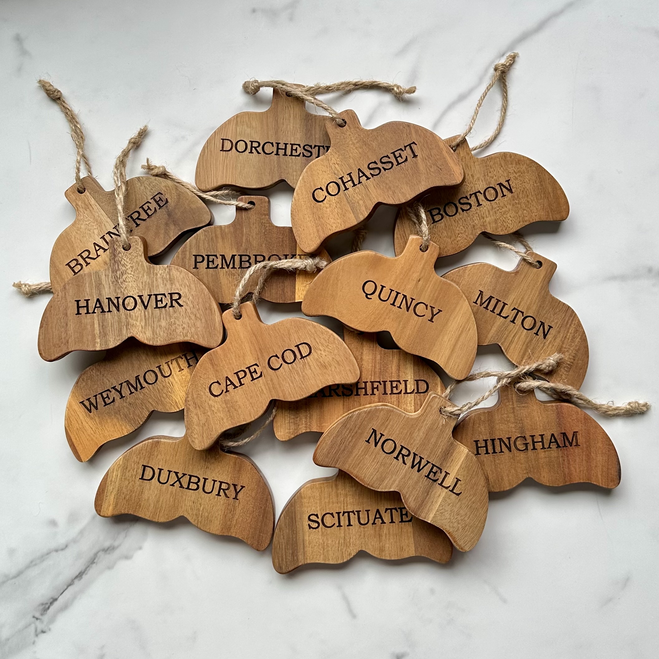 Collection of Cape Cod shaped ornaments with Massachusetts town names