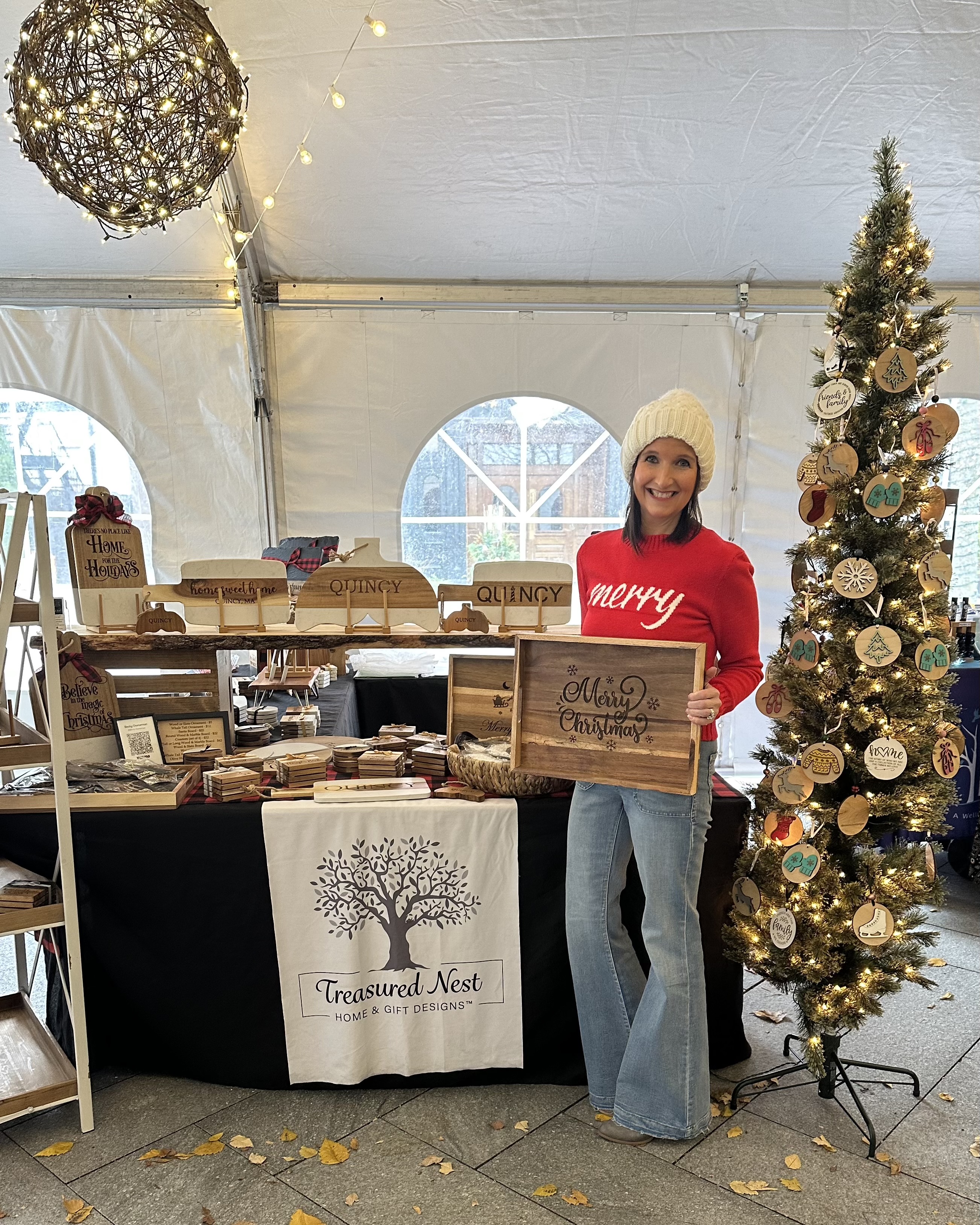 Becky at a craft fair displaying Treasured Nest Designs products