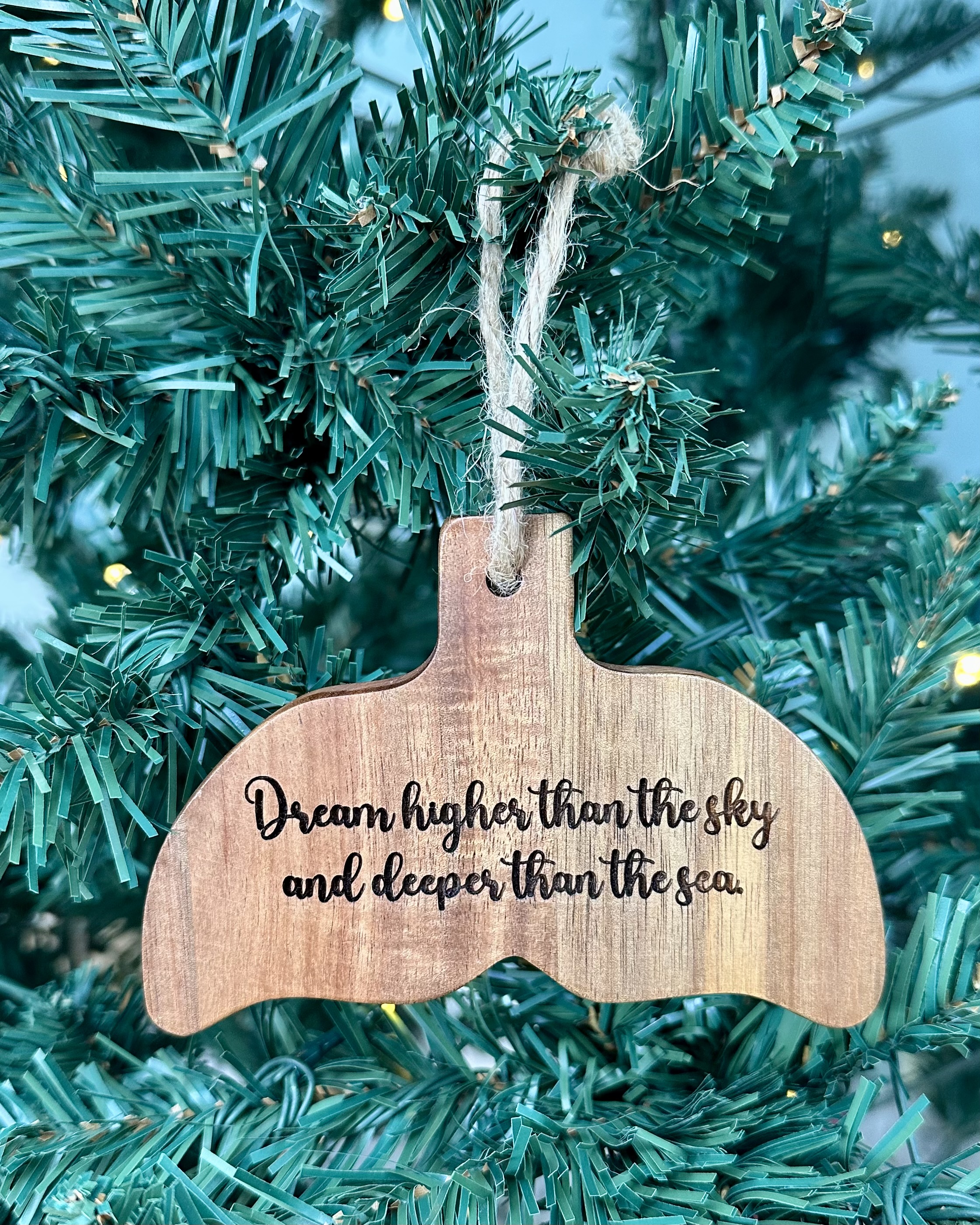 Wooden whale tail ornament with inspirational quote on Christmas tree